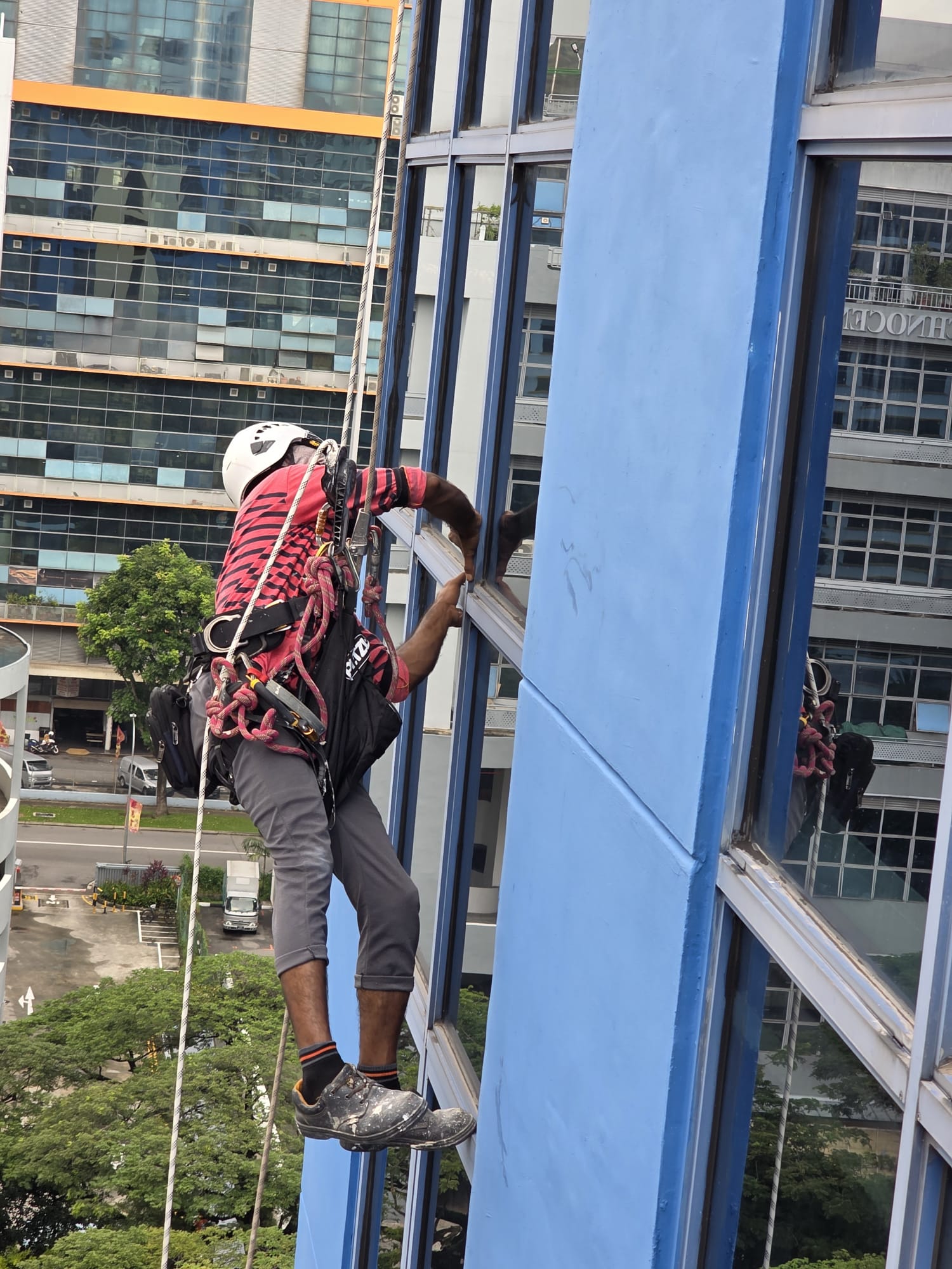 Rope-access worker beside a window at Bukit Batok Crescent