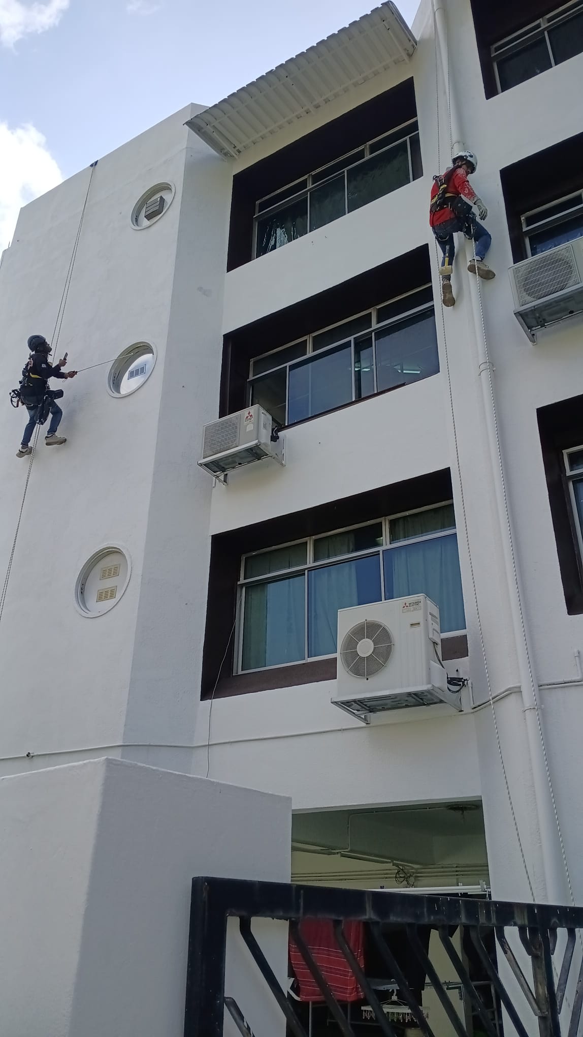 Rope-access workers on the white facade at Jalan Labu Ayer