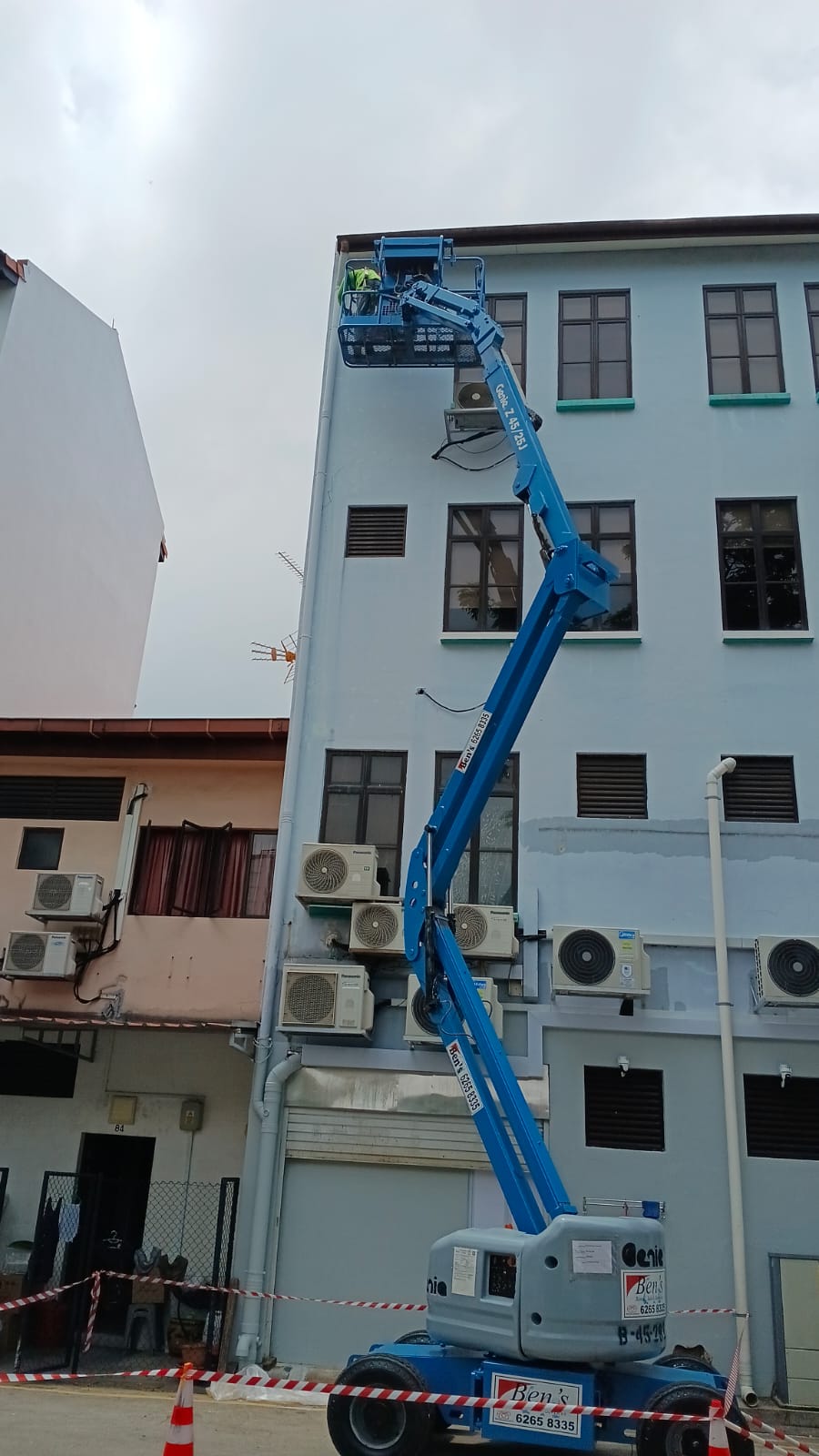 Boom lift reaching an upper shophouse facade at Joo Chiat Road