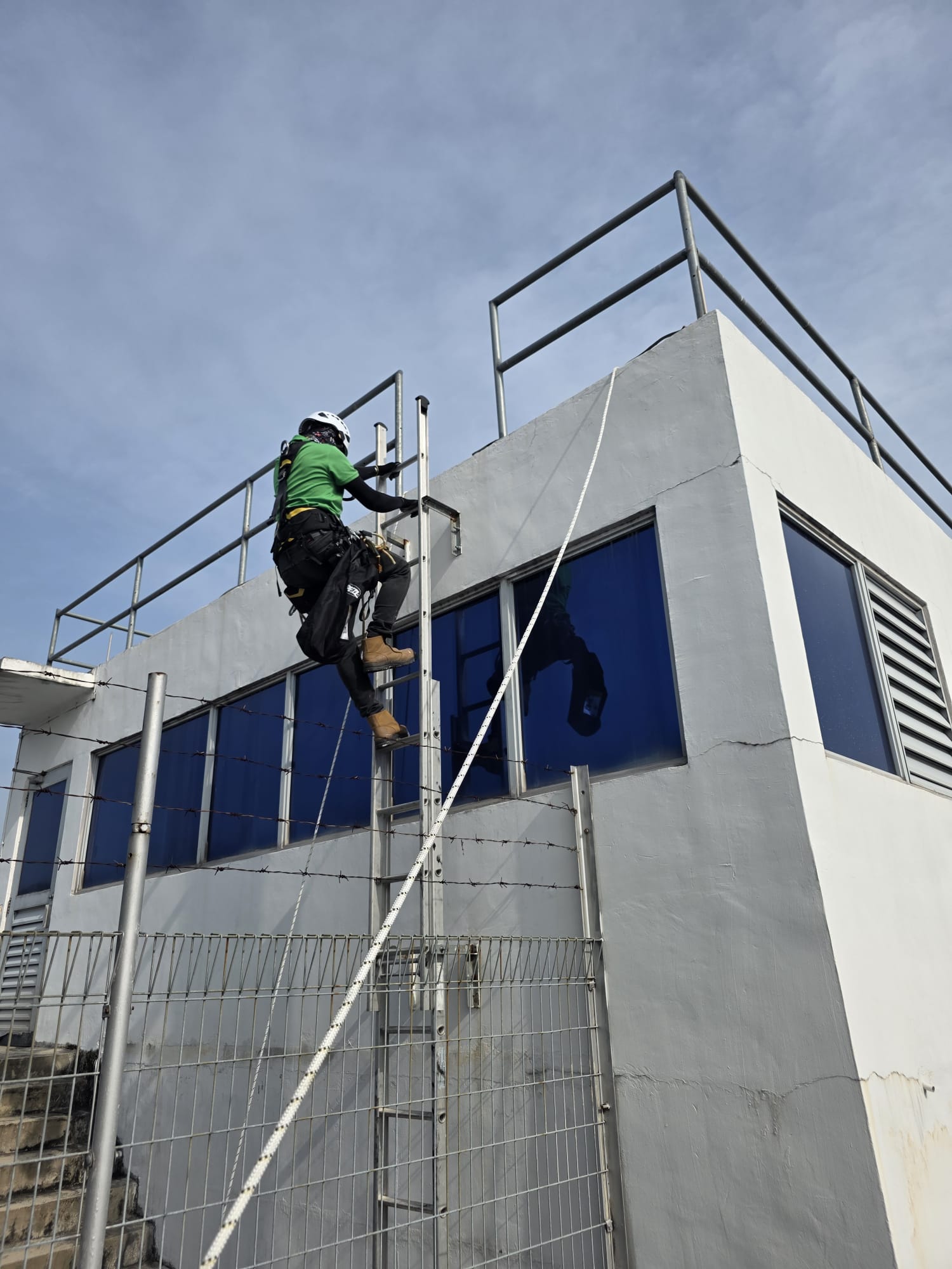 Worker accessing the upper facade edge at Toh Guan Road East